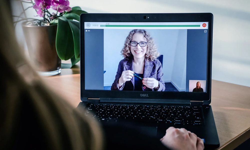 Patientin führt Sprechstunde mit Therapeutin auf Laptop durch.