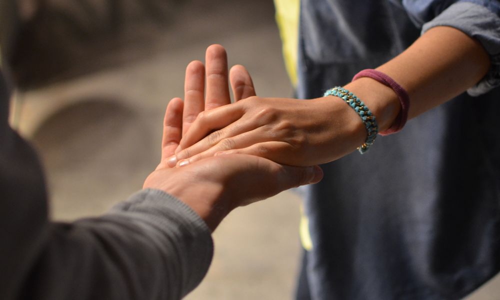 Zwei Hände berühren sich als Symbolbild für Unterstützung und Orientierung.